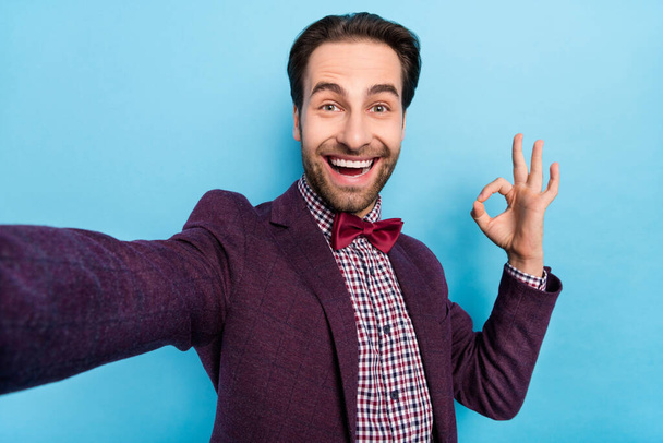 Photo of young cheerful handsome man make selfie show fingers okey symbol promo recommend isolated over blue color background - Φωτογραφία, εικόνα