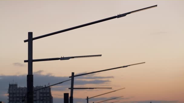 Closeup powerful street lamps silhouettes drone shot. Dark lamppost metal poles. - Footage, Video