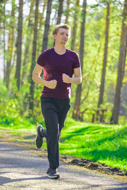 Man jogging in city partk at beautiful summer day. Sport fitness model caucasian ethnicity training outdoor. - Foto, Imagem