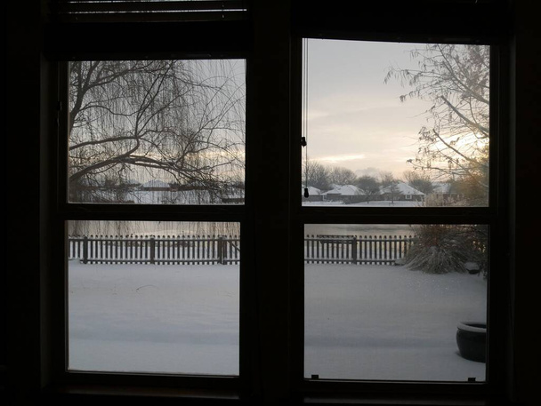 Ablakból kilátás nyílik egy havas hátsó udvarra - Fotó, kép