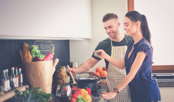 Couple cooking together in their kitchen at home - 写真・画像