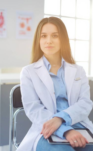 Female doctor using tablet computer in hospital lobby - Valokuva, kuva