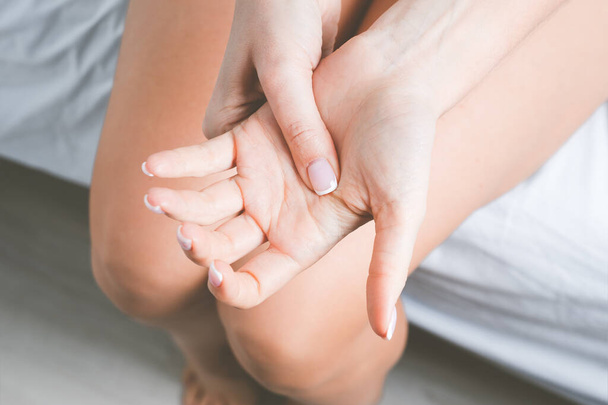 Γυναίκα που υποφέρει από πόνο στο χέρι ή πόνο στο δάχτυλο. Μούδιασμα χεριών ή μούδιασμα άκρων μετά τον ύπνο. Μασάζ οδυνηρό χέρι - Φωτογραφία, εικόνα