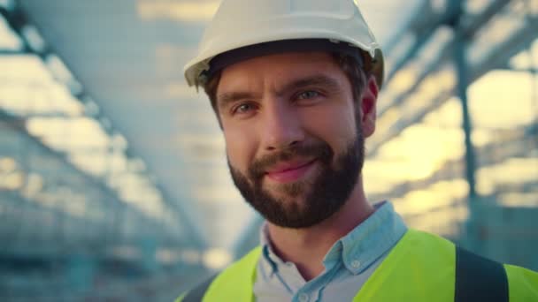 Portrait ingénieur d'usine souriant à la caméra appréciant le travail portant un casque blanc - Séquence, vidéo