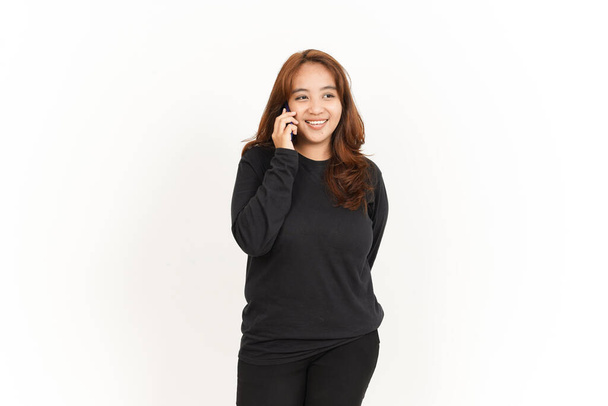 Puhuminen älypuhelimella kaunis aasialainen nainen yllään musta paita eristetty valkoisella taustalla - Valokuva, kuva