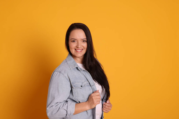Beautiful overweight woman with charming smile on yellow background. Space for text - Fotografie, Obrázek