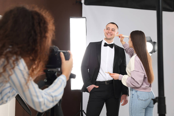Professional photographer and makeup artist with model in studio - Fotoğraf, Görsel
