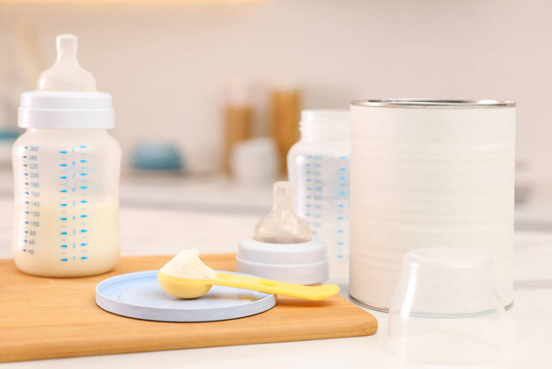 Feeding bottle with infant formula and powder on white table indoors - Foto, Bild