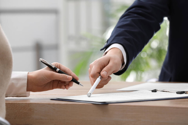 Businesspeople signing contract at table in office, closeup - Foto, afbeelding