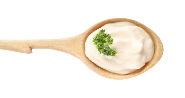 Cuillère en bois avec mayonnaise savoureuse et persil isolé sur blanc, vue sur le dessus - Photo, image