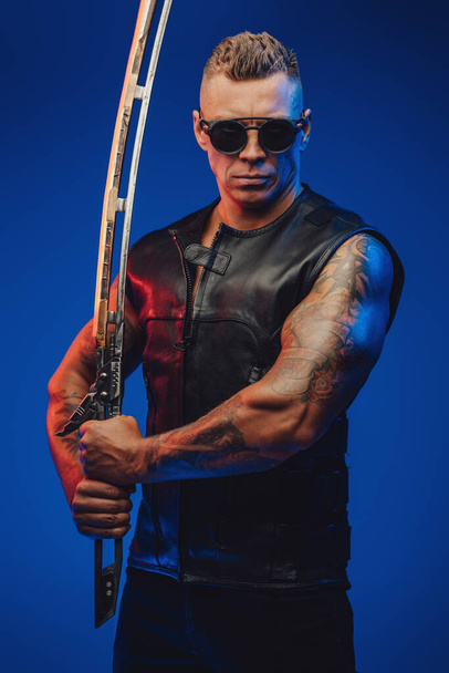 Izmos srác cyberpunk stílusban kard ellen kék háttér - Fotó, kép
