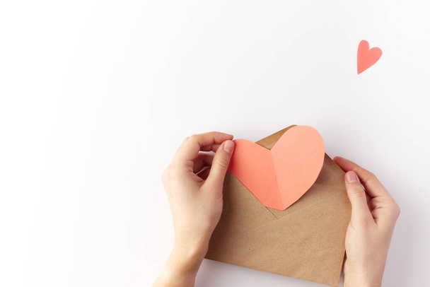 Valentines Day. Red heart made of paper on a white background in envelope. Copy space. Place for text. - Photo, Image