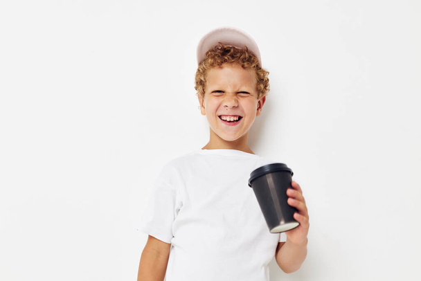 Cute little boy what kind of drink is the phone in hand communication light background unaltered - Fotografie, Obrázek