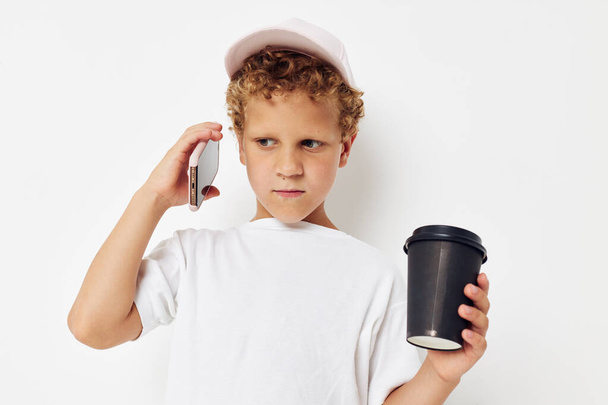Photo portrait curly little boy talking on the phone with a black glass isolated background unaltered - Valokuva, kuva