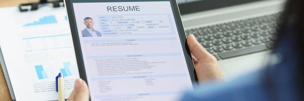 Woman employer holding digital tablet in hands with resume of man for employment closeup - Photo, Image
