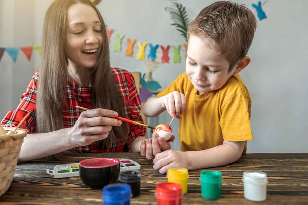 Mom and little child together are coloring eggs and having fun. Concept of family preparation for Easter, festive spring mood - Photo, image