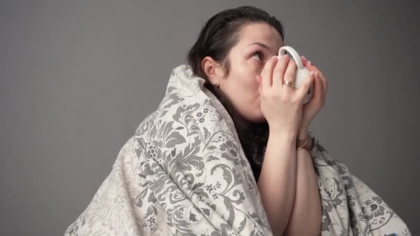 Ritratto di paziente donna stanca malata con tazza bianca seduta sul divano a casa che lotta contro i sintomi del virus dell'emicrania che beve tè caldo riscaldamento. - Filmati, video