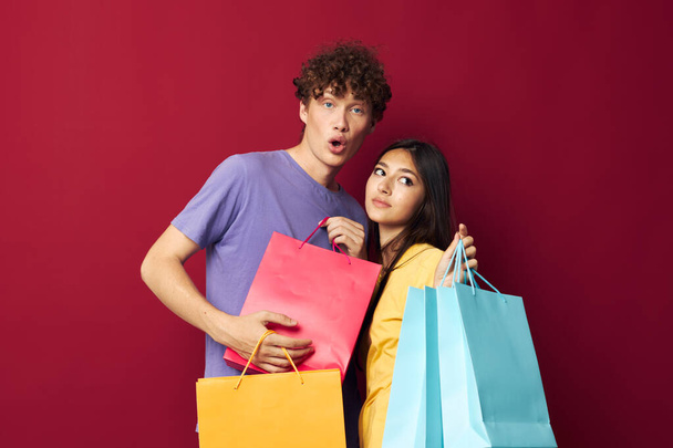 cute young couple colorful bags shopping fun isolated background unaltered - Zdjęcie, obraz