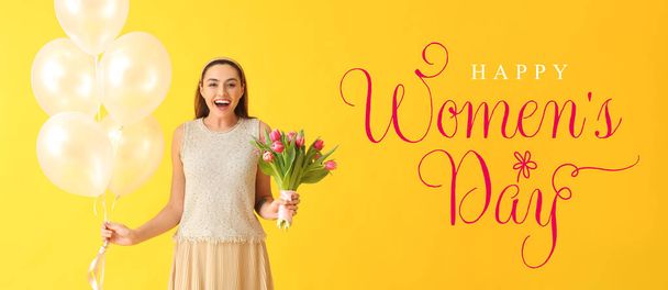 Mujer joven feliz con ramo de tulipanes y globos sobre fondo amarillo. Celebración del Día Internacional de la Mujer - Foto, imagen