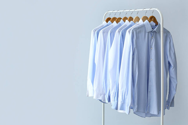 Rack with clean shirts on grey background - Foto, imagen
