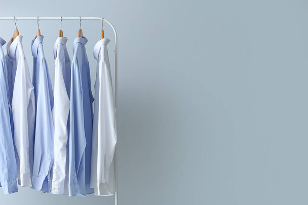 Rack with clean shirts on grey background - Fotoğraf, Görsel