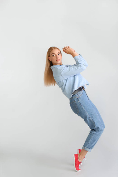 Fashionable young woman in stylish jeans clothes on light background - Foto, Imagem