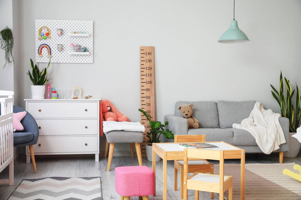 Интерьер стильной детской комнаты с комодом, диваном и пегбордом - Фото, изображение