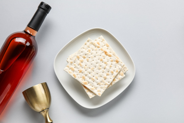 Jewish flatbread with goblet and bottle of wine on light background - Фото, изображение