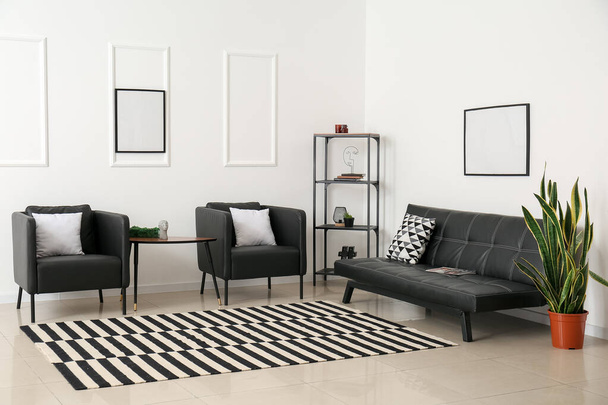 Belső tér világos nappali fekete fotelekkel, kanapéval és polccal - Fotó, kép