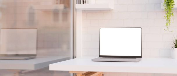 Close-up, Moderno espacio de trabajo de oficina con computadora portátil maqueta de pantalla blanca en la mesa blanca sobre la pared de ladrillo blanco cerca de una gran ventana de vidrio. representación 3d, ilustración 3d - Foto, imagen