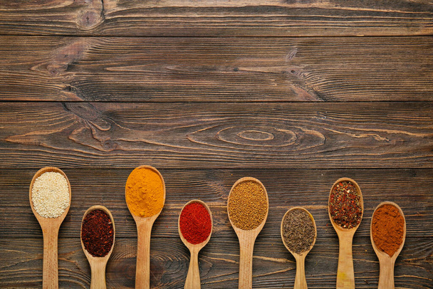 Spoons with spices on wooden background - Photo, Image