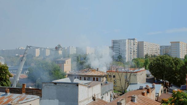 Vista de la casa en llamas y los bomberos tratando de extinguir el fuego - Foto, Imagen
