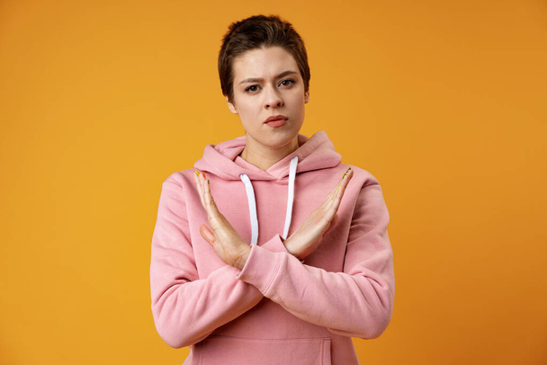 Young woman making a rejection gesture on a yellow background - Photo, Image