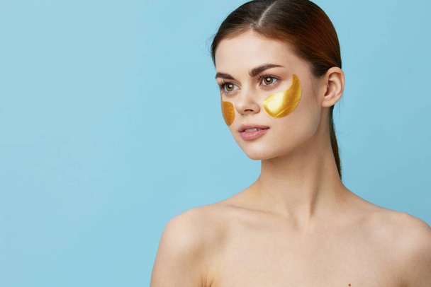 junge Frau goldene Flecken auf dem Gesicht isolierten Hintergrund - Foto, Bild