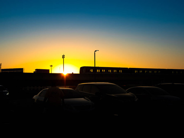 Σιλουέτα του ουρανού τρένο εισερχόμενη ή εξερχόμενη στο όμορφο ηλιοβασίλεμα. - Φωτογραφία, εικόνα