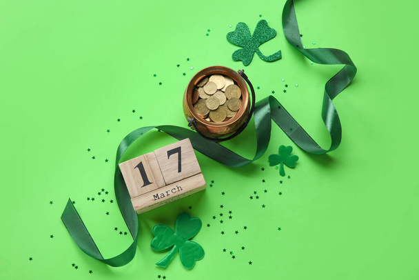 Kabouter pot met gouden munten en kalender met datum van St. Patrick 's Day op kleur achtergrond - Foto, afbeelding