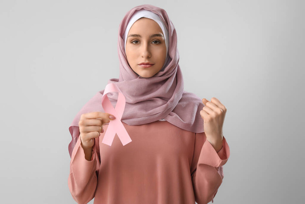 Musliminainen vaaleanpunaisella nauhalla kevyellä taustalla. Rintasyöpätietoisuuden käsite - Valokuva, kuva