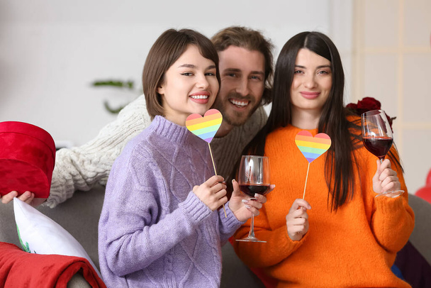 Homme et deux belles femmes célébrant la Saint-Valentin à la maison. Concept de polyamory et LGBT - Photo, image