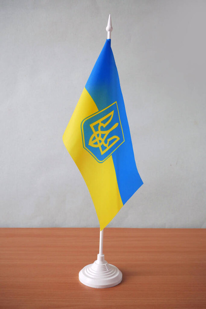 Modrá a žlutá Ukrajinská vlajka Wave CloseUp, vlajka stojí na stole, detailní - Fotografie, Obrázek