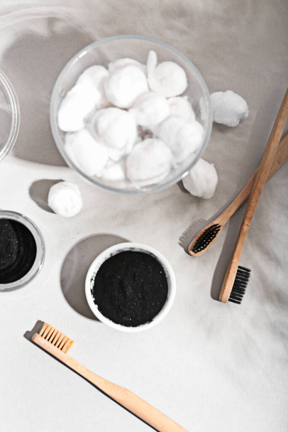 Composition with activated charcoal tooth powder and toothbrushes on light background - Foto, Bild