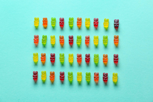 Süße Gummibärchen auf türkisfarbenem Hintergrund - Foto, Bild