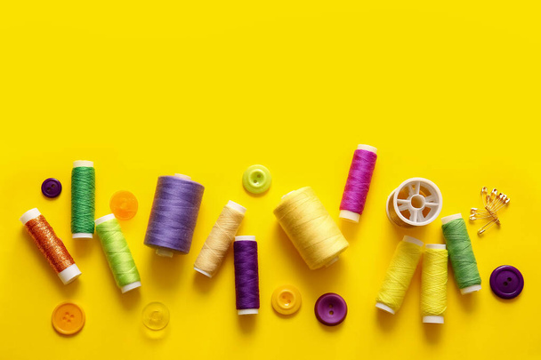 Carretéis de rosca com botões e pinos no fundo amarelo - Foto, Imagem