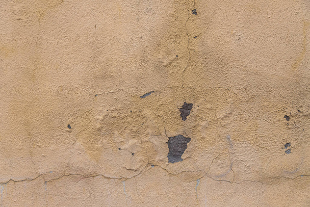 Παλιός πέτρινος τοίχος καλυμμένος με ξεφλούδισμα χρώματος, υφή grunge φόντο - Φωτογραφία, εικόνα