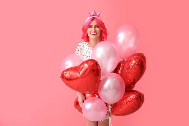 Статильна жінка з яскравим волоссям і повітряними кульками на кольоровому фоні. День святого Валентина. - Фото, зображення