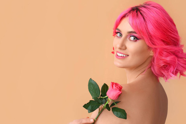 Femme élégante avec des cheveux brillants et rose fleur sur fond de couleur - Photo, image