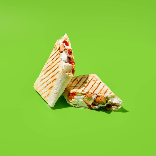 Shawarma with vegetables and meat on green background. Contemporary poster with shawarma. Doner kebab in minimal style. Street food concept. Junk food design. Minimalistic fast food menu - Fotoğraf, Görsel