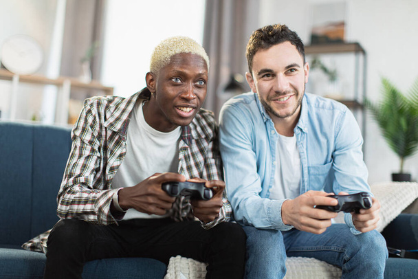 Multi ethnic same sex couple playing video games at home - Fotoğraf, Görsel