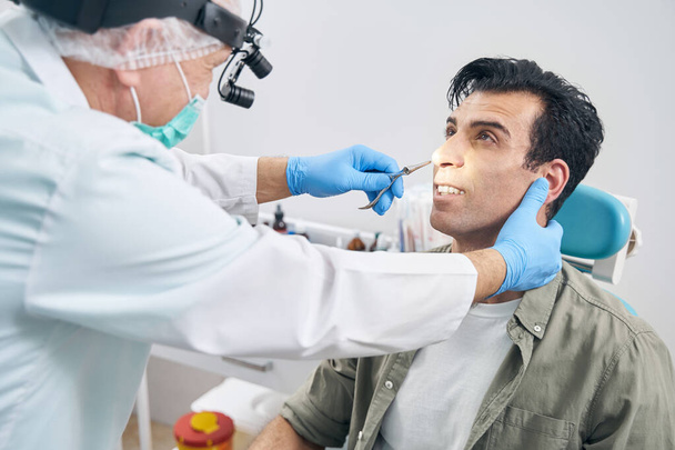 Мужчина на осмотре оториноларинголога в больнице - Фото, изображение