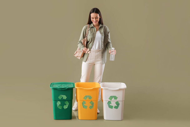 Nuori nainen lajittelu muovipullo ja paperi väri tausta - Valokuva, kuva