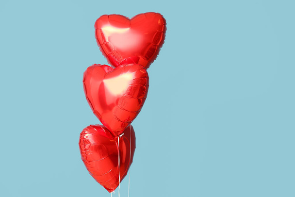 Beautiful heart-shaped balloons for Valentine's Day celebration on blue background - Fotoğraf, Görsel